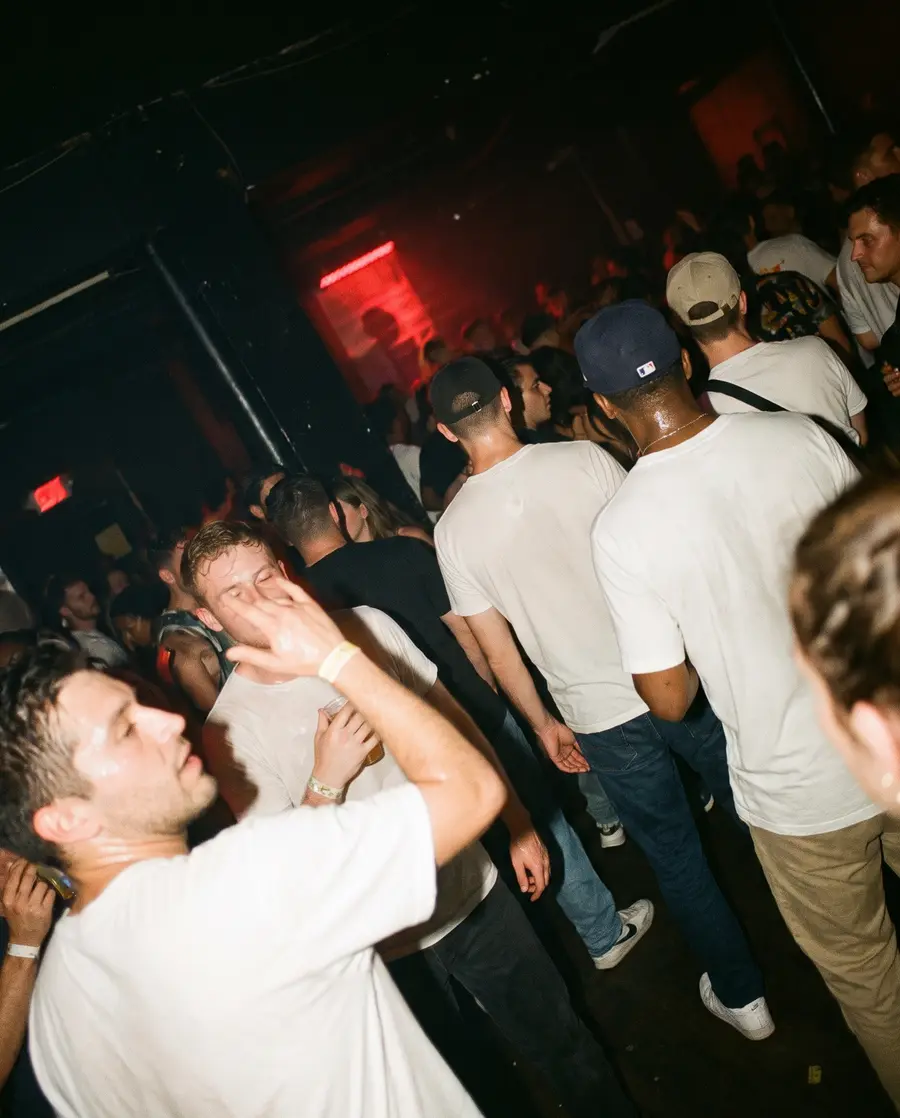 Dansend publiek in een donkere club, gefotografeerd met flits.